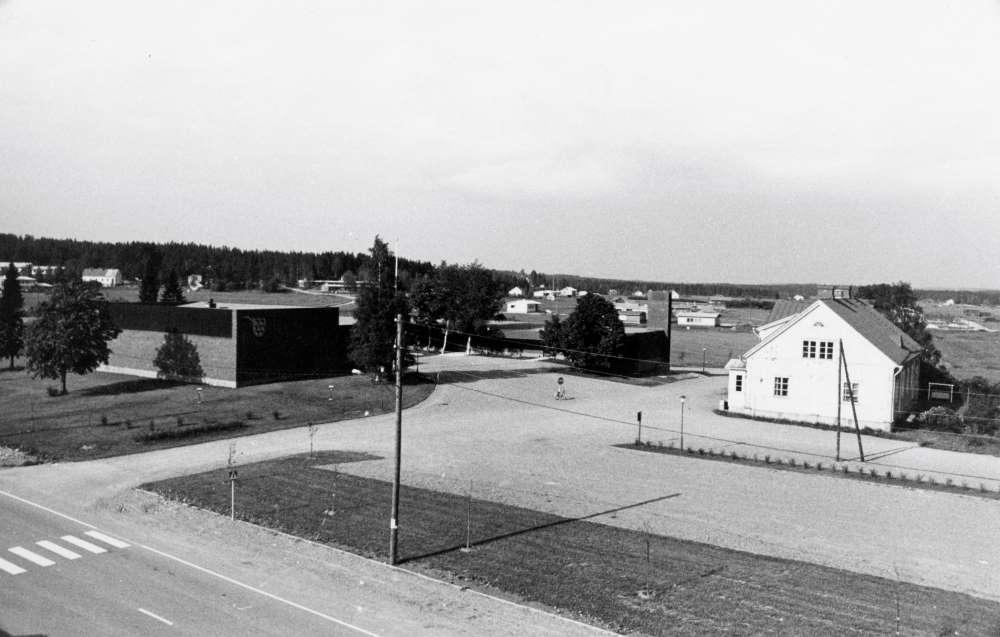 Kylänäkymä kirkonkylästä 1960-luvun lopusta. Risteyksen takana vasemmalla uusi kunnanvirasto, oikealla vanha kunnanvirasto Heikkari.