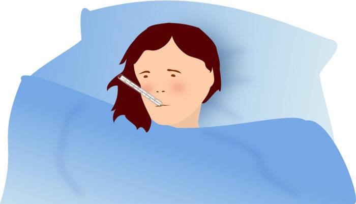 Influenssapotilas vuoteessa kuumemittari suussa