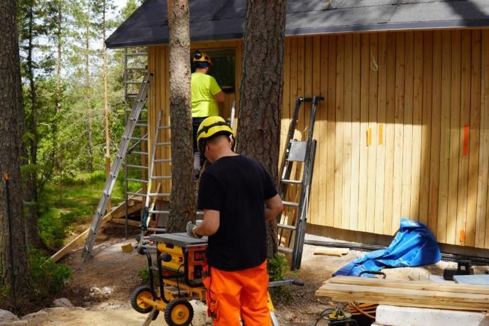 Kaksi työmiestä rakentaa Taaborinvuorelle sosiaalitilaa esiintyjille.