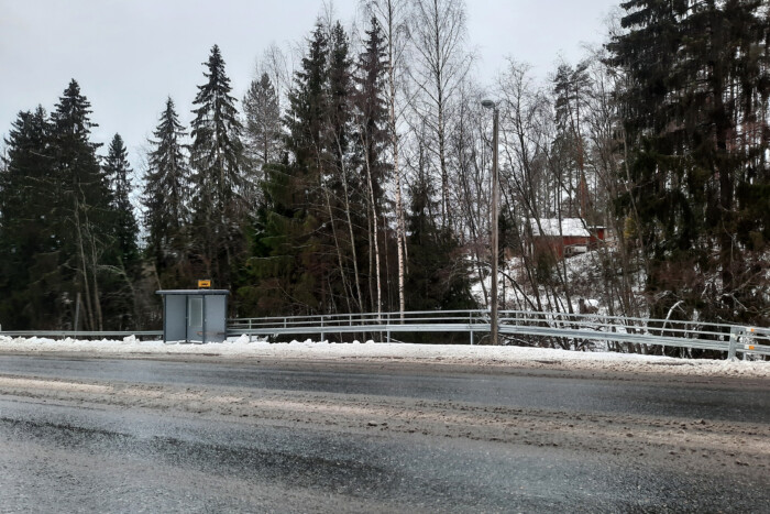 Linja-autopysäkki Klaukkalantien varressa. Taustalla näkyy asuinrakennuksia.
